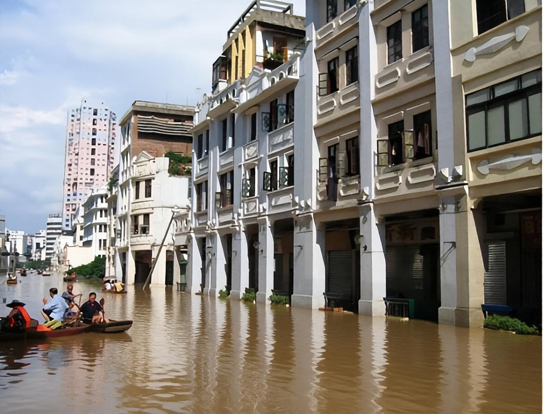 被浑浊洪水淹没的骑楼老街上,居民划着小木船在积水中通行,两侧是连片的复古骑楼建筑。
